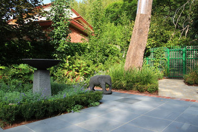 Photo of a mid-sized country backyard formal garden for spring in Melbourne with natural stone pavers.