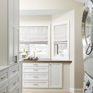 ミネアポリスの中サイズのトラディショナルスタイルのおしゃれな洗濯室 (シェーカースタイル扉のキャビネット、白いキャビネット、ベージュの壁、カーペット敷き、上下配置の洗濯機・乾燥機、茶色い床、茶色いキッチンカウンター) の写真