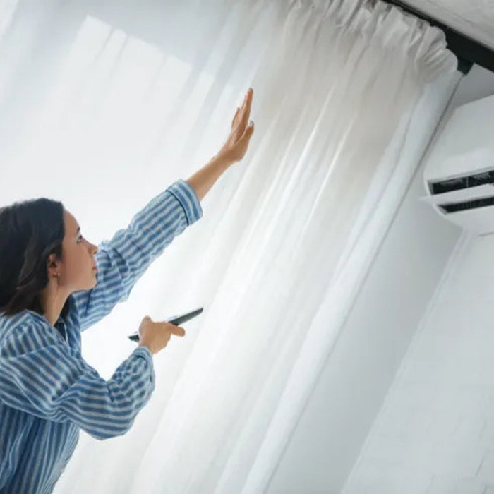 woman reaching to see if air conditioning is working