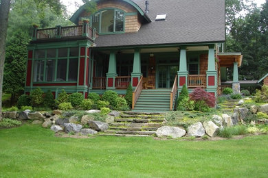 This is an example of a large contemporary front yard full sun garden for spring in New York with a garden path and natural stone pavers.