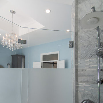 Traditional master bath utilizing frosted and clear glass to allow for needed pr