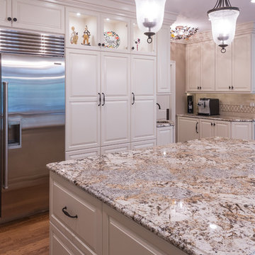 White raised panel maple cabinets are accented with Caravelas-Gold granite.