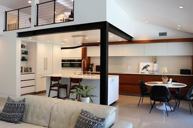Inspiration for a contemporary concrete floor and gray floor eat-in kitchen remodel in Orange County with a single-bowl sink, light wood cabinets, quartz countertops, white backsplash, stainless steel appliances, an island and white countertops