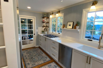 Enclosed kitchen - mid-sized transitional l-shaped medium tone wood floor and brown floor enclosed kitchen idea in Seattle with a single-bowl sink, recessed-panel cabinets, white cabinets, quartz countertops, white backsplash, quartz backsplash, stainless steel appliances, no island and white countertops