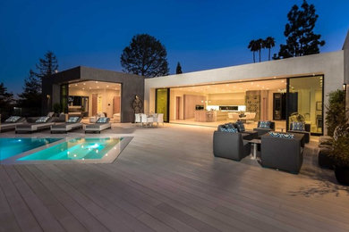 Large modern backyard rectangular lap pool in Los Angeles with a hot tub and decking.