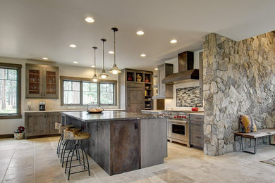 Large mountain style l-shaped travertine floor and beige floor eat-in kitchen photo in Denver with recessed-panel cabinets, dark wood cabinets, stainless steel appliances, an island, granite countertops, multicolored backsplash and matchstick tile backsplash
