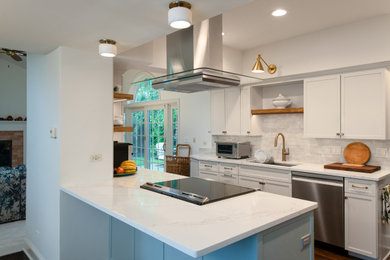 Open concept kitchen - mid-sized transitional galley dark wood floor and brown floor open concept kitchen idea in Chicago with an undermount sink, shaker cabinets, white cabinets, quartz countertops, beige backsplash, porcelain backsplash, stainless steel appliances, a peninsula and white countertops