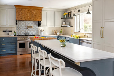 Kitchen - modern u-shaped medium tone wood floor and brown floor kitchen idea in Other with an integrated sink, blue cabinets, white backsplash, stainless steel appliances, an island and white countertops