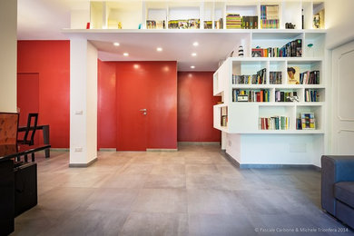 Ispirazione per un soggiorno moderno aperto con libreria, pareti rosse, pavimento in gres porcellanato e pavimento grigio
