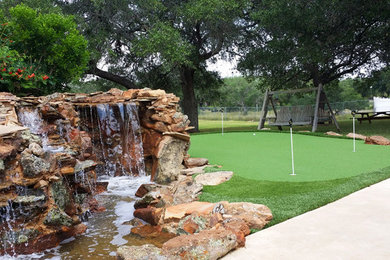 Inspiration for a mid-sized traditional full sun backyard pond in Dallas.