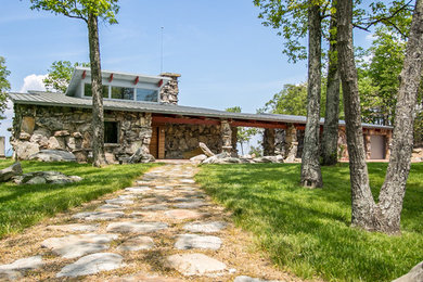 This is an example of a large modern two-storey grey exterior in Other with stone veneer.