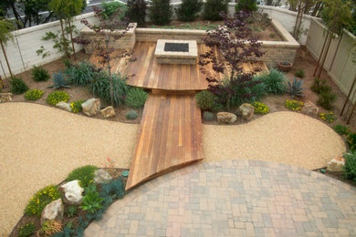 Photo of a mid-sized contemporary drought-tolerant and full sun backyard brick landscaping in San Diego.