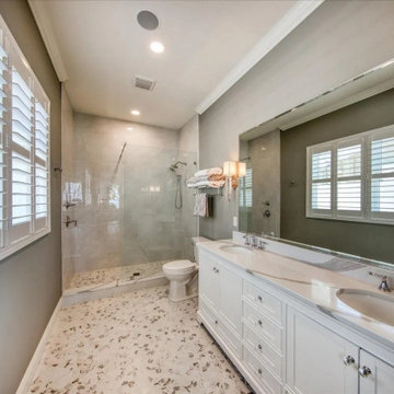 Minimal White-Tile Bath With Double Vanity and Glass Shower