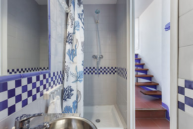 Example of a small beach style 3/4 gray tile shower curtain design in Barcelona with stainless steel countertops