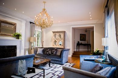 Example of a large eclectic formal and enclosed medium tone wood floor living room design in Los Angeles with beige walls, a standard fireplace, a wood fireplace surround and no tv