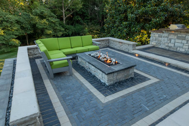 Mid-sized arts and crafts backyard concrete paver patio photo in St Louis with a fire pit and no cover