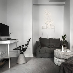 Idéer för mellanstora skandinaviska hemmabibliotek, med vita väggar, ett fristående skrivbord och betonggolv