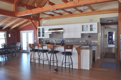 Eat-in kitchen - contemporary single-wall medium tone wood floor eat-in kitchen idea in Providence with a double-bowl sink, stainless steel appliances, gray backsplash, wood backsplash, shaker cabinets, white cabinets and an island