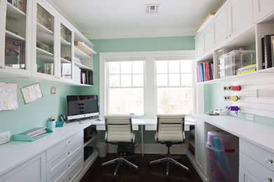 Inspiration for a contemporary craft room in New York with green walls, dark hardwood floors and a built-in desk.