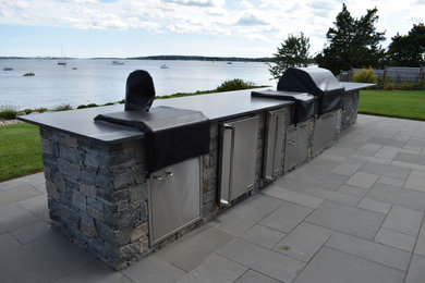 Inspiration for a large transitional backyard stone patio kitchen remodel in Providence with no cover