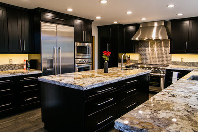 Example of a minimalist u-shaped light wood floor eat-in kitchen design in Denver with shaker cabinets, granite countertops, metallic backsplash, glass tile backsplash, stainless steel appliances and an island