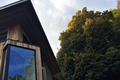 Inspiration for a large contemporary multicolored two-story mixed siding exterior home remodel in West Midlands with a mixed material roof
