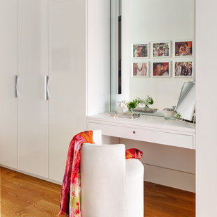 Inspiration for a scandinavian women's medium tone wood floor dressing room remodel in New York with flat-panel cabinets and white cabinets