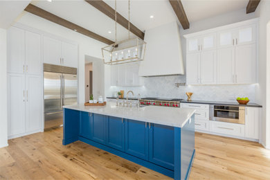 Open concept kitchen - large contemporary exposed beam open concept kitchen idea in Santa Barbara with a farmhouse sink, shaker cabinets, white cabinets, quartz countertops, white backsplash, quartz backsplash, stainless steel appliances, an island and white countertops