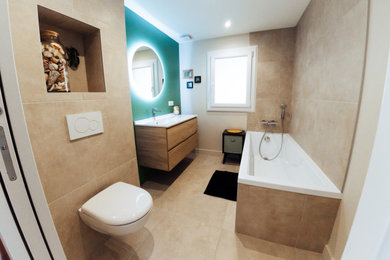 Small country family bathroom in Bordeaux with a submerged bath, a wall mounted toilet, beige tiles, ceramic tiles, beige walls, ceramic flooring, a wall-mounted sink, concrete worktops, beige floors, white worktops, a wall niche, a single sink and a built in vanity unit.