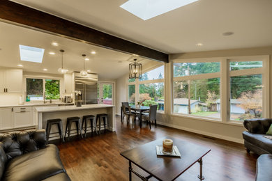Example of a minimalist medium tone wood floor and brown floor kitchen design in Seattle with shaker cabinets, white cabinets, stainless steel appliances and white countertops