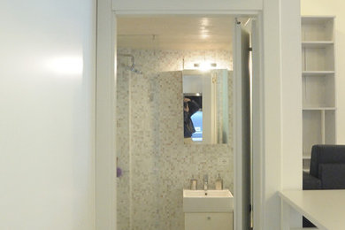 ミラノにあるお手頃価格の小さなコンテンポラリースタイルのおしゃれなバスルーム (浴槽なし) (フラットパネル扉のキャビネット、白いキャビネット、バリアフリー、分離型トイレ、白いタイル、モザイクタイル、白い壁、コンクリートの床、壁付け型シンク、グレーの床、開き戸のシャワー) の写真