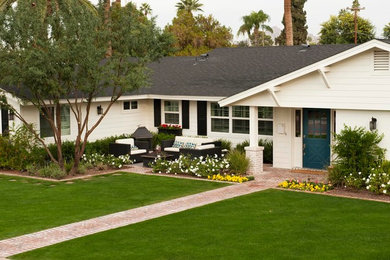 This is an example of a mid-sized traditional front yard brick landscaping in Phoenix with a fire pit.