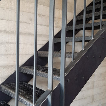 Treppen und Geländer zu hohen Sichtbetonwänden