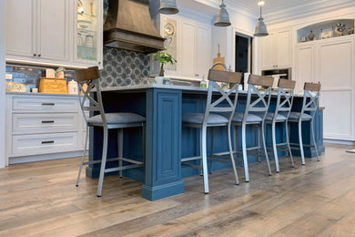 Kitchen - victorian u-shaped medium tone wood floor and brown floor kitchen idea in Chicago with a double-bowl sink, recessed-panel cabinets, white cabinets, granite countertops, multicolored backsplash, porcelain backsplash, stainless steel appliances, an island and gray countertops