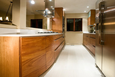 Inspiration for a mid-sized contemporary galley open concept kitchen remodel in Denver with an undermount sink, flat-panel cabinets, medium tone wood cabinets, solid surface countertops, beige backsplash, stainless steel appliances and no island