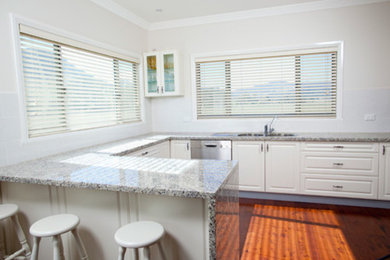 This is an example of a mid-sized traditional u-shaped separate kitchen in Sydney with with island.