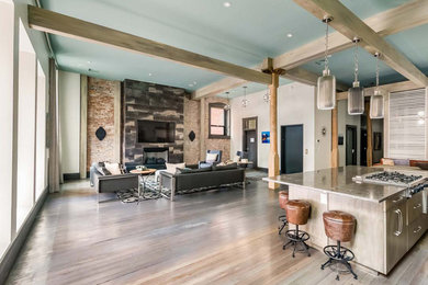 Example of a huge trendy open concept light wood floor living room design in Nashville with beige walls, a standard fireplace, a stone fireplace and a wall-mounted tv