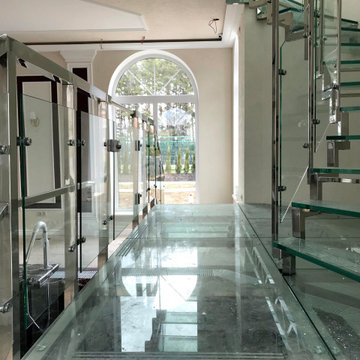 Винтовая стеклянная лестница над бассейном