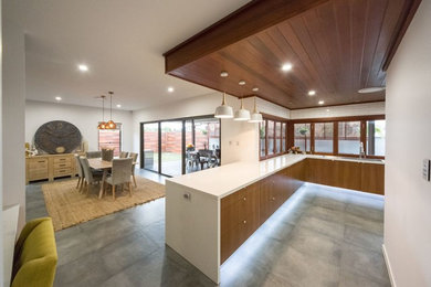 Inspiration for a large contemporary u-shaped eat-in kitchen in Brisbane with a double-bowl sink, flat-panel cabinets, medium wood cabinets, white splashback, ceramic splashback, stainless steel appliances and with island.