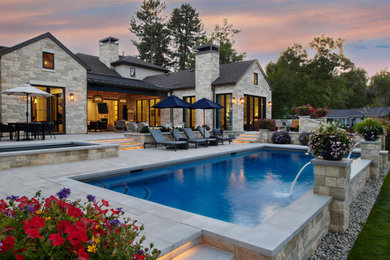 Example of a large classic backyard concrete paver and rectangular pool design in Denver