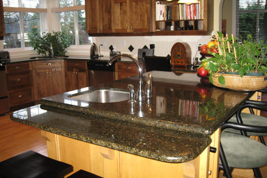 Foto de cocinas en L contemporánea grande con fregadero bajoencimera, encimera de granito, electrodomésticos de acero inoxidable, suelo de madera clara y una isla