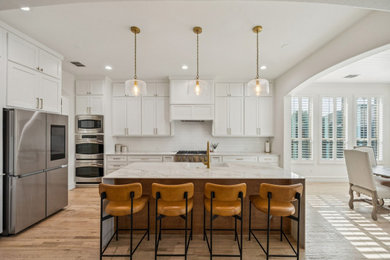 Eat-in kitchen - transitional l-shaped light wood floor and beige floor eat-in kitchen idea in Dallas with an undermount sink, shaker cabinets, white cabinets, white backsplash, mosaic tile backsplash, stainless steel appliances, an island and white countertops