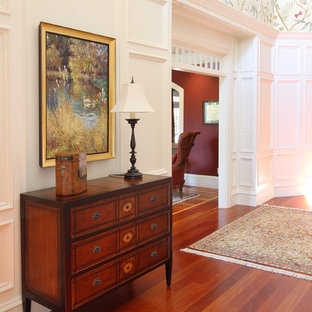 Exempel på en stor klassisk hall, med flerfärgade väggar och mellanmörkt trägolv