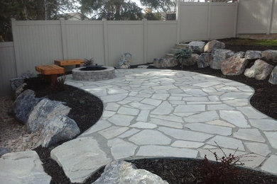 Photo of a large traditional drought-tolerant and partial sun backyard stone landscaping in Salt Lake City with a fire pit for summer.