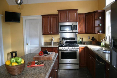 ポートランド(メイン)にあるおしゃれなアイランドキッチン (ダブルシンク、フラットパネル扉のキャビネット、中間色木目調キャビネット、白い調理設備、磁器タイルの床) の写真