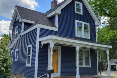 Modelo de fachada de casa azul y negra clásica de tamaño medio de dos plantas con revestimiento de vinilo, tejado de un solo tendido, tejado de teja de madera y tablilla