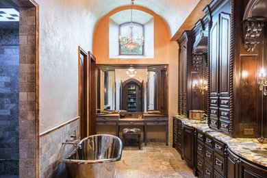Inspiration for a large mediterranean master gray tile freestanding bathtub remodel in Austin with an undermount sink, recessed-panel cabinets, dark wood cabinets and beige walls