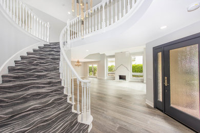 Inspiration for a contemporary medium tone wood floor single front door remodel in Orange County with white walls