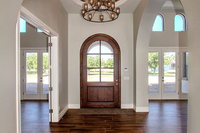 Inspiration for a mid-sized transitional entryway in Phoenix with beige walls, light hardwood floors, a single front door, a glass front door and brown floor.