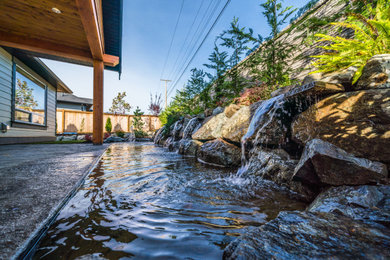 This is an example of a small contemporary backyard concrete paver waterfall in Other.